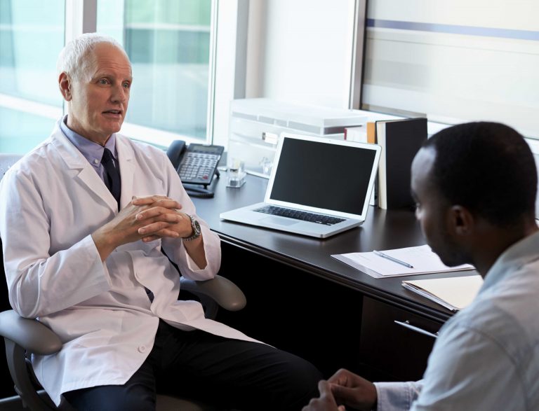 Médico urologista conversando com o paciente sobre a possibilidade de reverter a vasectomia